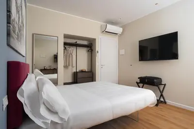a bedroom with a white bed and a flat screen tv at Attico 37 - Comfort room con terrazza privata in Palermo