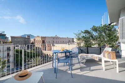 a balcony with a table and chairs and a view of the city at Attico 37 - Queen room con terrazza privata in Palermo
