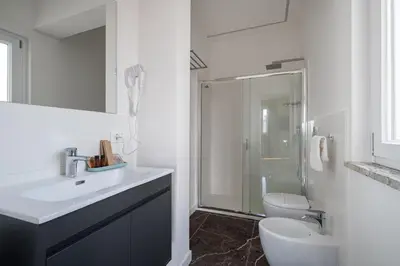 a white bathroom with a sink and a toilet at Attico 37 - Queen room con terrazza privata in Palermo