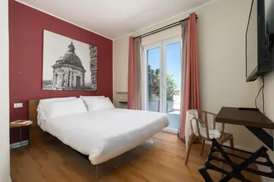 a bedroom with a large white bed and a window at Attico 37 - Queen room con terrazza privata in Palermo