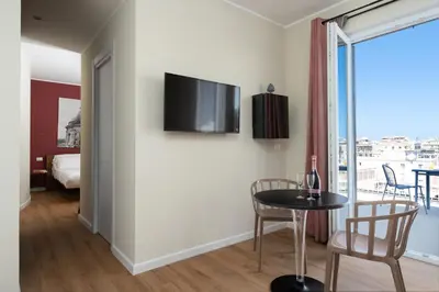 a room with a table and a tv on a wall at Attico 37 - Queen room con terrazza privata in Palermo