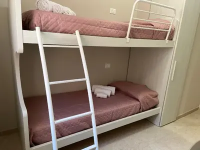 two bunk beds in a small room with towels at Luce del golfo in Castellammare del Golfo