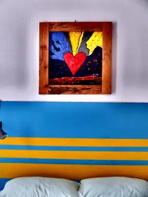 a painting of a heart on a window above a bed at AlCasart in Alcamo