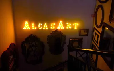 a neon sign that says massage on a wall at AlCasart in Alcamo
