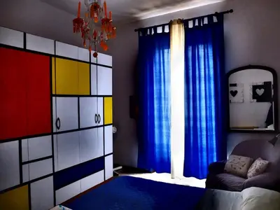 a bedroom with colorful curtains and a couch and a chandelier at AlCasart in Alcamo