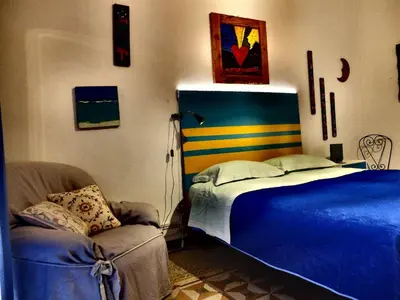 a bedroom with a blue bed and a chair at AlCasart in Alcamo