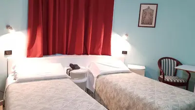 a room with two beds and a red curtain at Addaura Village e Congressi in Mondello
