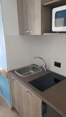 a kitchen counter with a sink and a microwave at Addaura Village e Congressi in Mondello