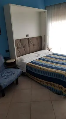 a bedroom with a bed and a bench in it at Addaura Village e Congressi in Mondello