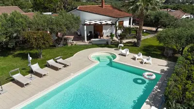 an overhead view of a swimming pool with chairs and a house at Villa New Charme in Castellammare del Golfo