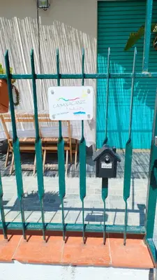 a green fence with a sign on top of it at L'isola di Fimi in Isola delle Femmine
