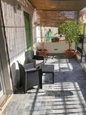 a patio with chairs and tables and potted plants at L'isola di Fimi in Isola delle Femmine