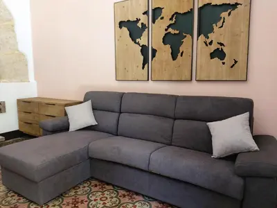 a living room with a couch and a map of the world at La Casetta di Giò! in Castellammare del Golfo