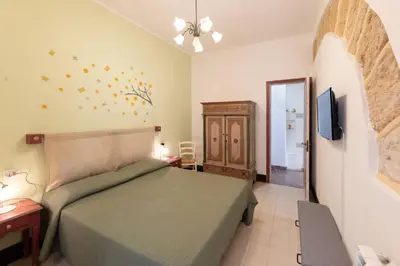 a bedroom with a bed and a dresser and a television at La Casetta di Giò! in Castellammare del Golfo
