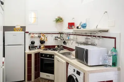 a kitchen with a white refrigerator and a microwave at La Casetta di Giò! in Castellammare del Golfo