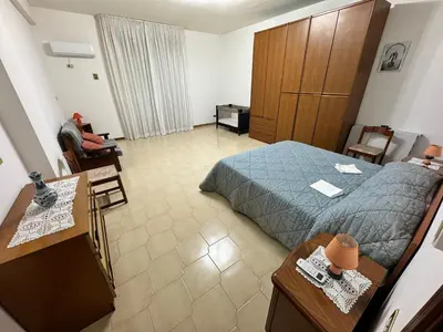 a hotel room with a bed and a person sitting in a chair at Villa con piscina 