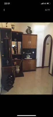 a living room with wooden furniture and a cat laying on the floor at Villa con piscina 