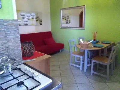 a living room with a couch and a table and a kitchen at VILLETTA MAGNOLIE by Trerose Properties - Villetta indipendente con wi-fi e posto auto gratuito in San Vito lo Capo