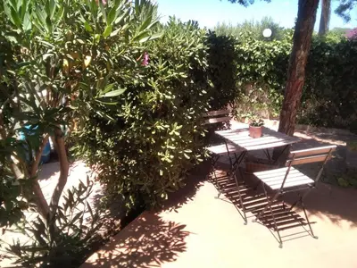 a picnic table and two chairs next to a bush at VILLETTA MAGNOLIE by Trerose Properties - Villetta indipendente con wi-fi e posto auto gratuito in San Vito lo Capo
