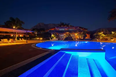 a swimming pool lit up at night at Magaggiari Hotel Resort in Cinisi