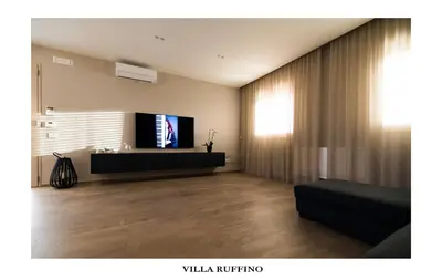 a living room with a couch and a television at Appartamento in Villa con idromassaggio in Balestrate