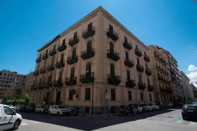 a large building with cars parked in front of it at Hotel Tonic in Palermo