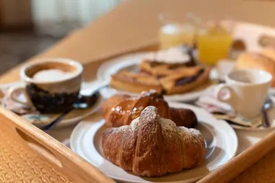 a tray with plates of pastries and cups of coffee at Hotel Tonic in Palermo