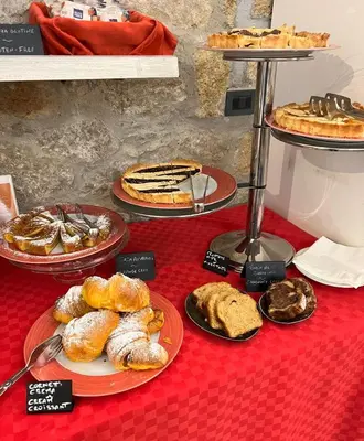 a table topped with plates of pastries and pies at Hotel Tonic in Palermo