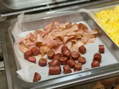 a tray of food with sausage and bacon on it at Hotel Tonic in Palermo