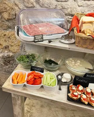 a shelf with vegetables and meat and other foods at Hotel Tonic in Palermo