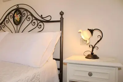 a bedroom with a bed and a nightstand with a lamp at Desy Appartamenti in San Vito lo Capo