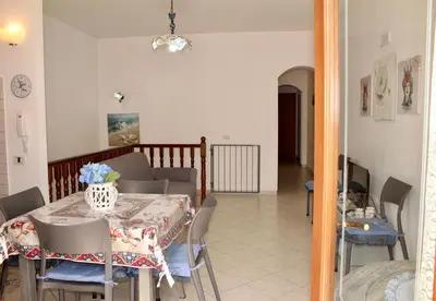 a dining room table with a vase on top of it at Desy Appartamenti in San Vito lo Capo