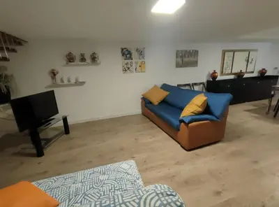 a living room with a blue couch and a television at Casa Costantino in Alcamo