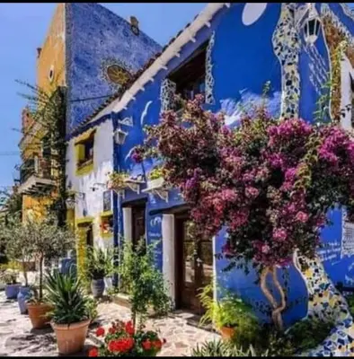 a blue building with a bunch of flowers on it at Casa Costantino in Alcamo