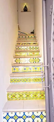 a stairway with white and yellow tiles on the stairs at Via Roma 35 Apartament in Monreale