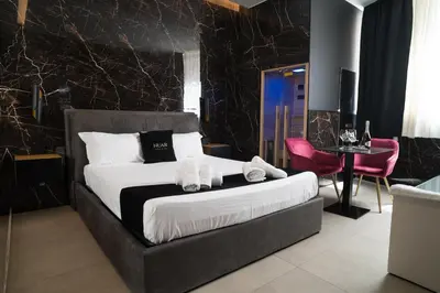 a bedroom with a king sized bed and a table at Nuar suite&spa in Palermo