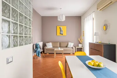 a white bedroom with a bed and a yellow blanket at Sedie Volanti Apartment with Jacuzzi in Palermo