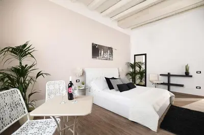 a white living room with a white bed and chairs at iFlat Dalla Zia Anna in Palermo