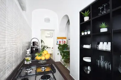 a kitchen with black cabinets and a stove in a room at iFlat Dalla Zia Anna in Palermo