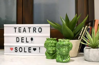 two green figurines sitting on a table next to a plant at iFlat Dalla Zia Anna in Palermo