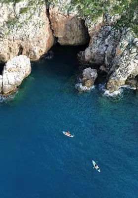 two boats in the water in front of a cave at Elima's Mood in Scopello