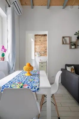 a white dining room with a table and chairs at Casa dei Quattro Canti B&B in Palermo