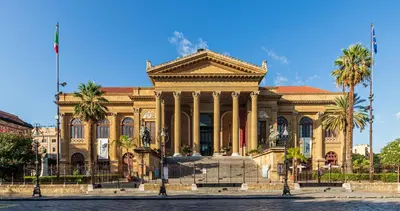 a large building with palm trees in front of it at Casa dei Quattro Canti B&B in Palermo