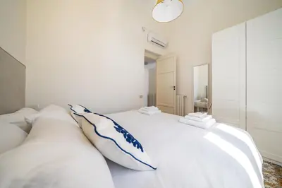 a white bedroom with a large white bed with pillows at I Merli sull'acqua - Suite in Palermo