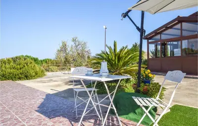a table and two chairs and an umbrella at Cozy Home In Caccamo With Kitchenette in Caccamo