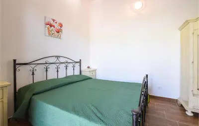 a bedroom with a bed with a green comforter at Cozy Home In Caccamo With Kitchenette in Caccamo