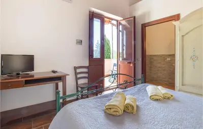 a bedroom with a bed with towels on it at Cozy Home In Caccamo With Kitchenette in Caccamo