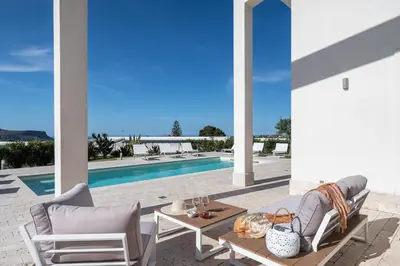 a patio with a table and chairs and a pool at Villa Costamante con piscina privata in Balata di Baida