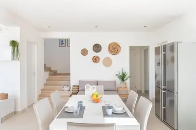 a white dining room with a white table and chairs at Villa Costamante con piscina privata in Balata di Baida