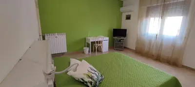 a green room with a bed and a television at Il Gabbiano al Capo in Palermo